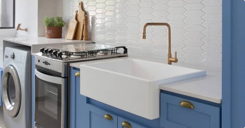 Móveis planejados em cozinha azul e branca com cuba farm de apoio