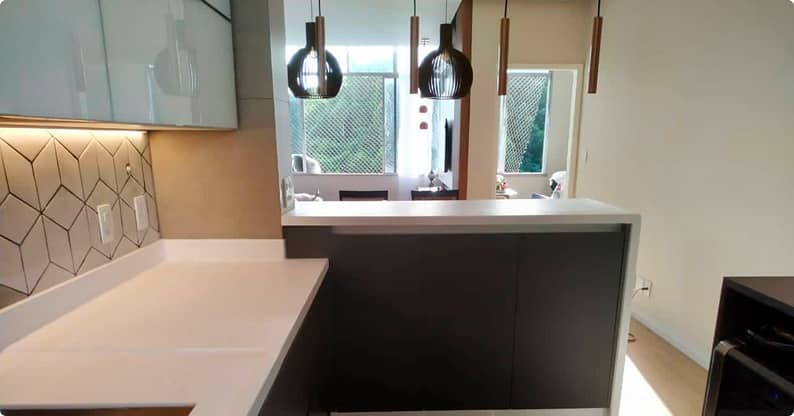 Móveis planejados em cozinha moderna com ilha central e parede geométrica